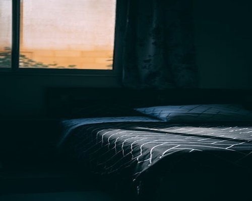 A minimalist dark bedroom setting prepared for comfortable sleep